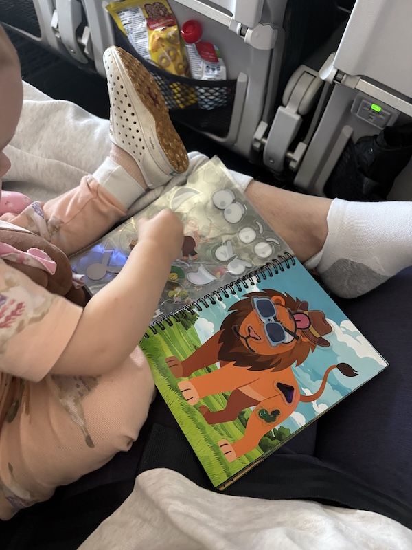 flying with a toddler under 2 - sticker book entertainment on a plane